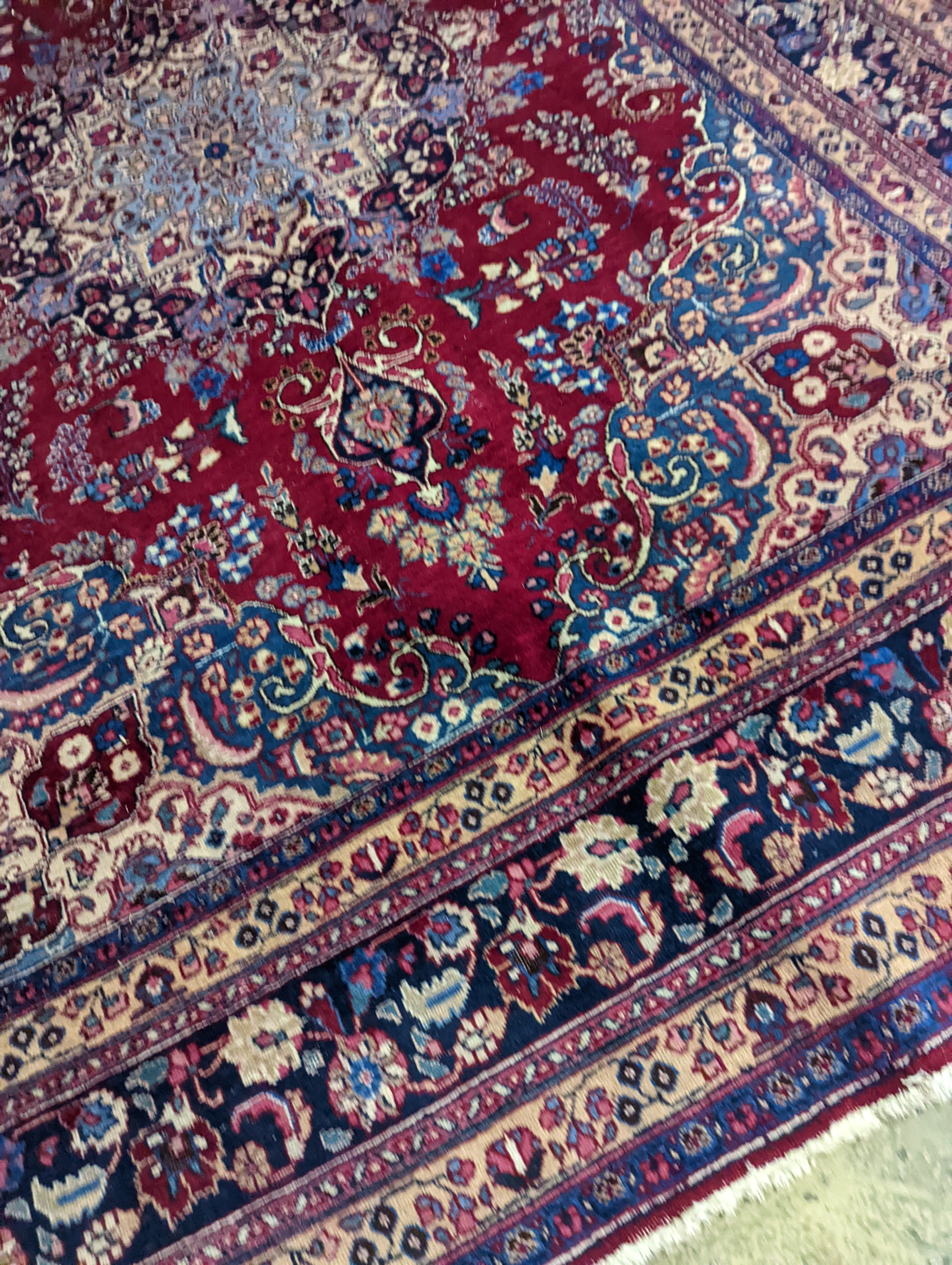 A Tabriz burgundy ground carpet, 350 x 250cm